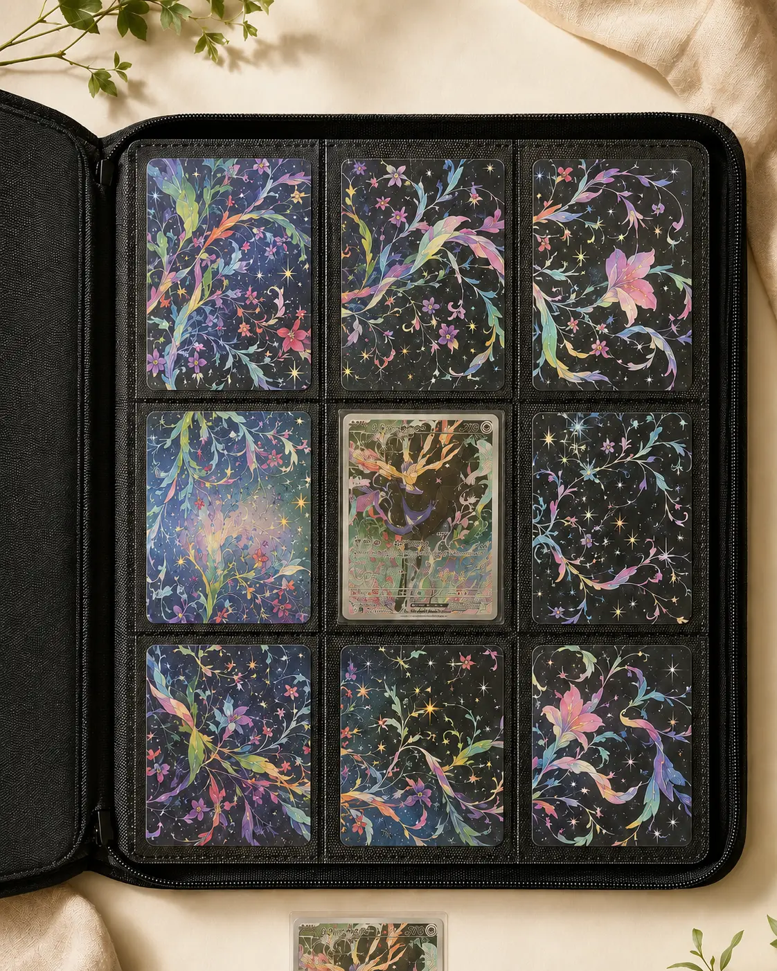 Nine-pocket trading card binder page with connected floral and cosmic artwork panels surrounding a central collector card